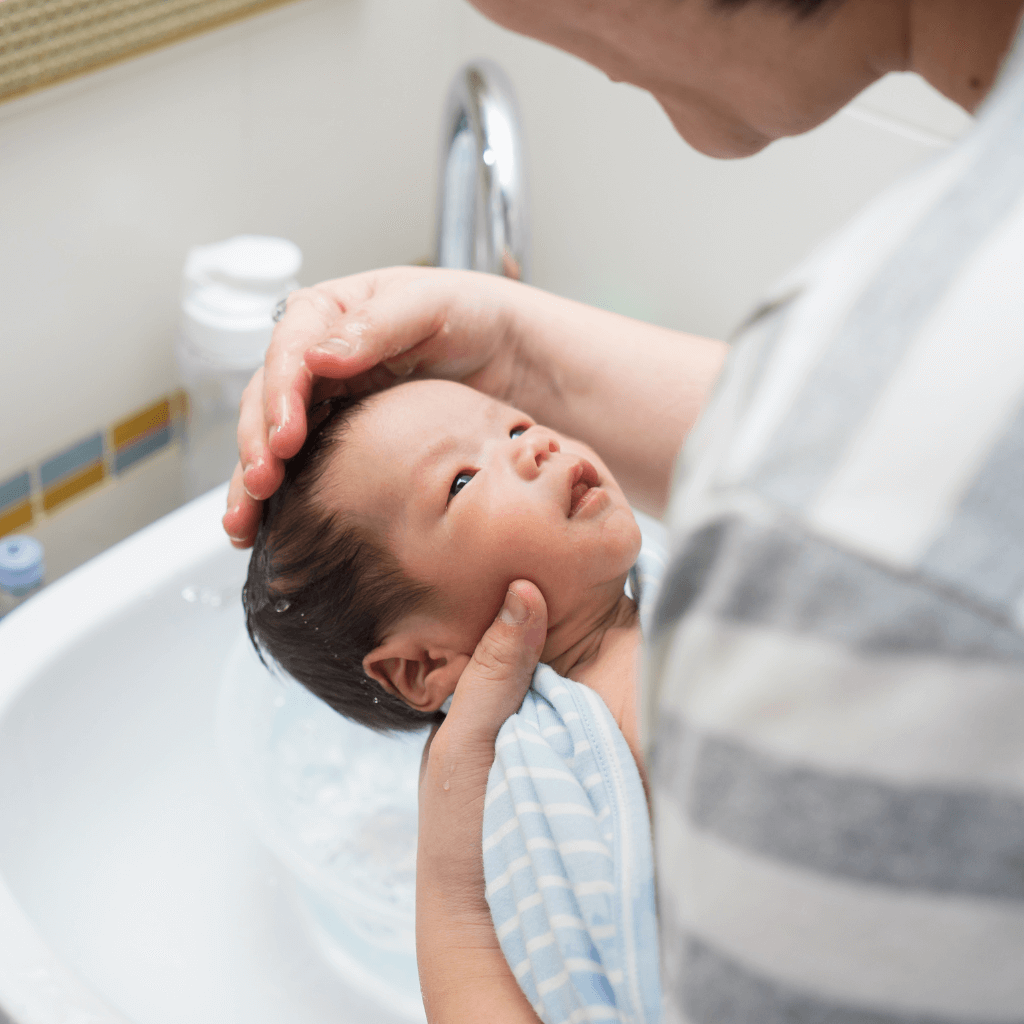 Uma Mãe banha cuidadosamente o seu Bebê